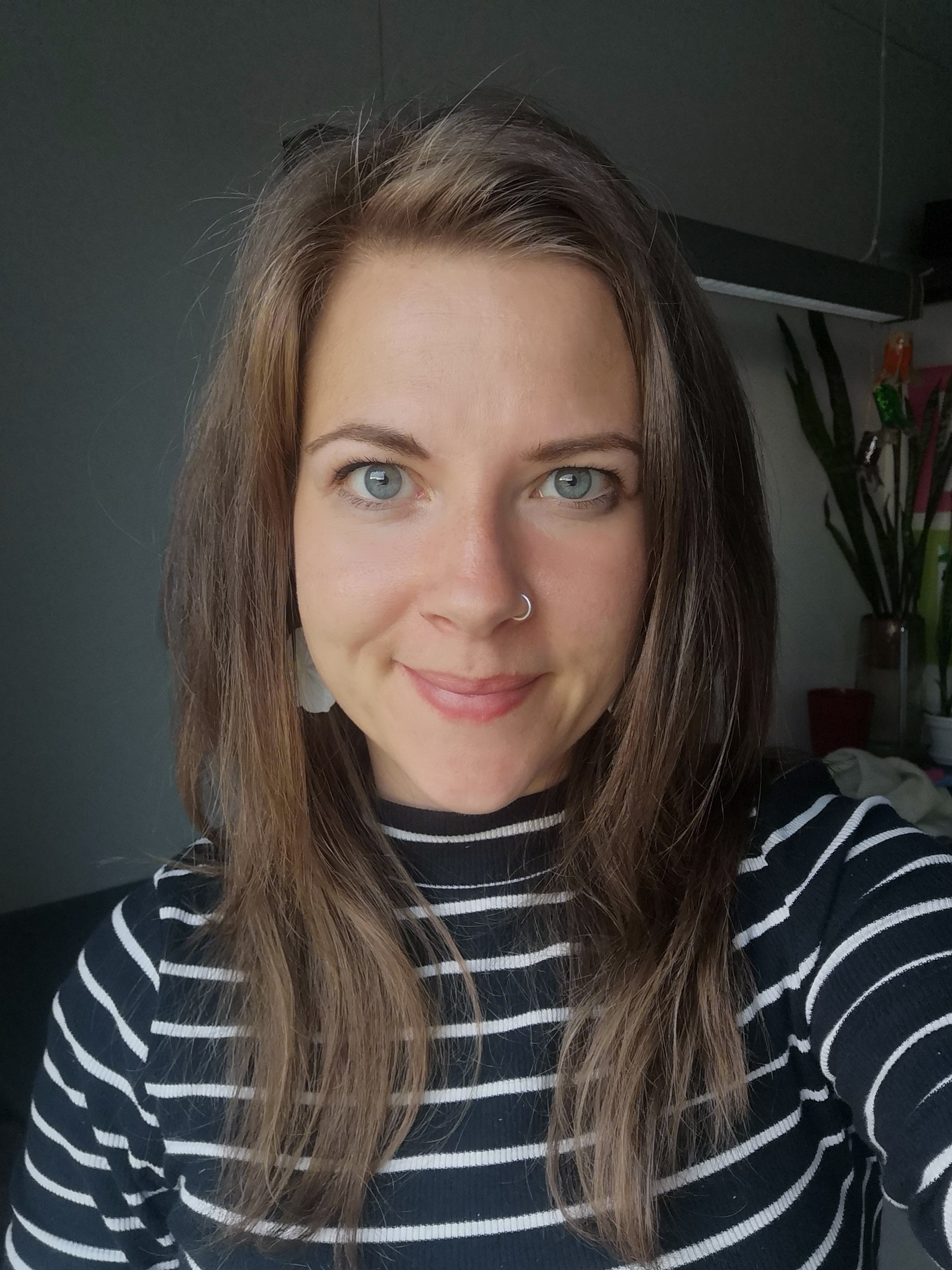 Mynd av Alisu. Hon hyggur beint í eyguni á tær við einum fittum skálkasmíli. Hon hevur leyst hár, sum fellir niður á akslarnar og er í eini stríputari, hvítari og svartari blusu.