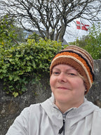 Person wearing a striped headband with a natural background of trees and foliage.