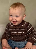 Child wearing a brown patterned sweater against a neutral background