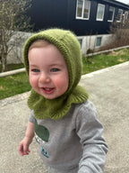 Child wearing a green knitted balaclava outdoors