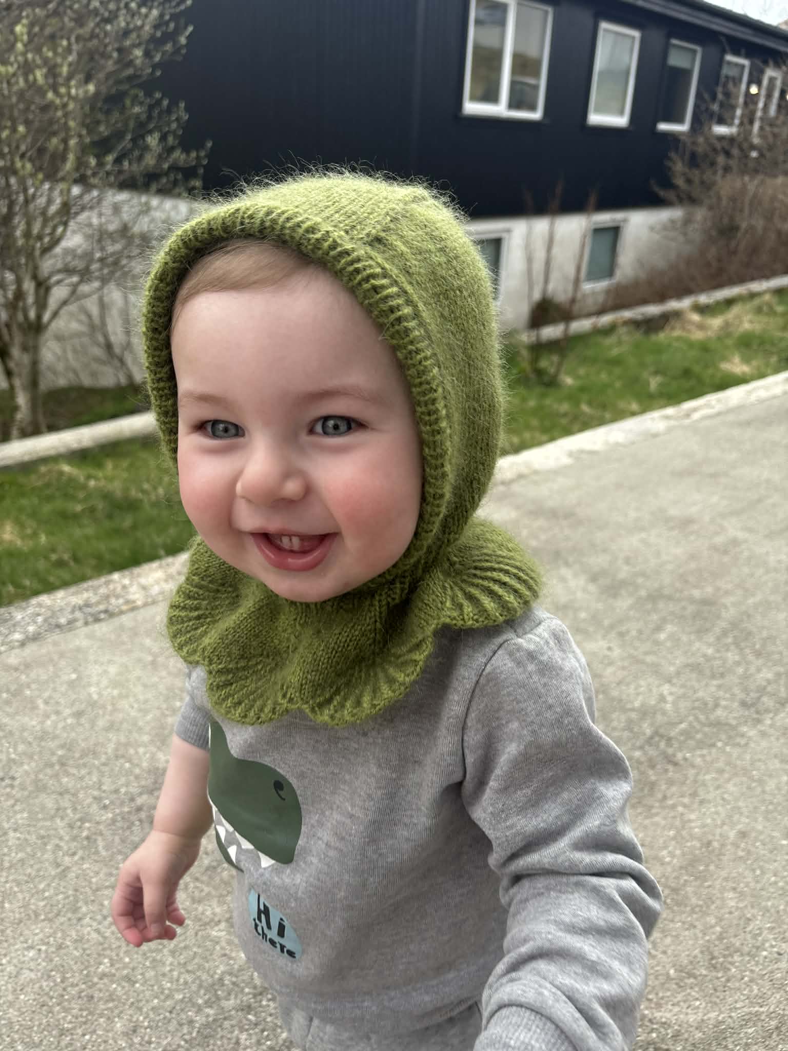 Child wearing a green knitted balaclava outdoors