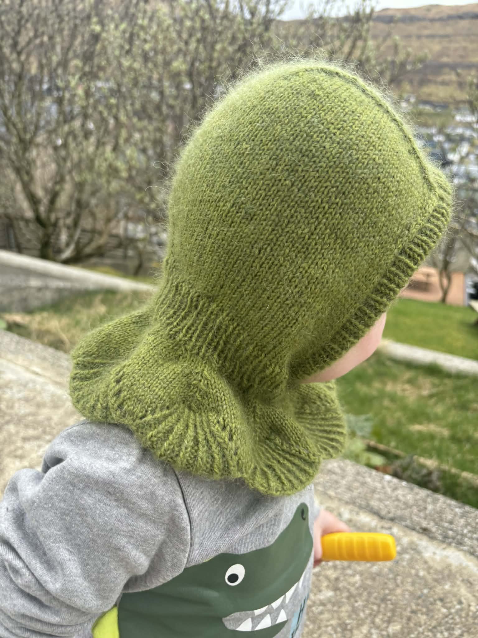 Child wearing a green knitted balaclava
